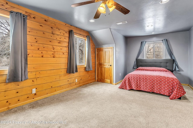 bedroom featuring carpet flooring, lofted ceiling, ceiling fan, and wooden walls