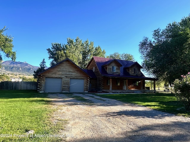 log cabin featuring a mountain view, a front lawn, and a garage