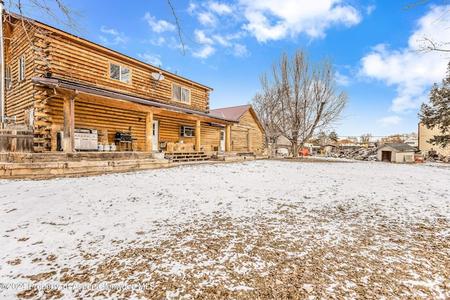 view of snow covered back of property