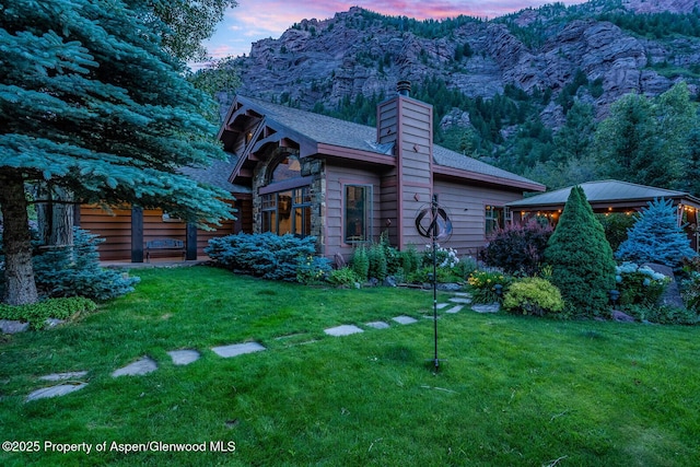 606 Dorais Way, Redstone, CO 81623 - property exterior at dusk featuring a chimney, a yard, a gazebo, and a mountain view