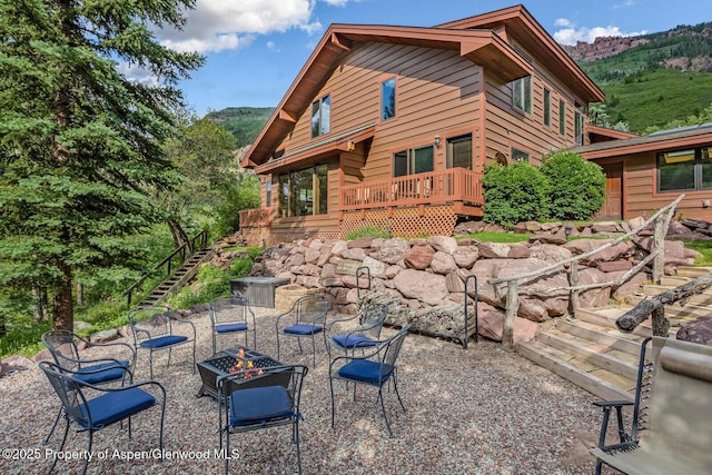 606 Dorais Way, Redstone, CO 81623 - rear view of house featuring a fire pit, stairs, and a deck with mountain view