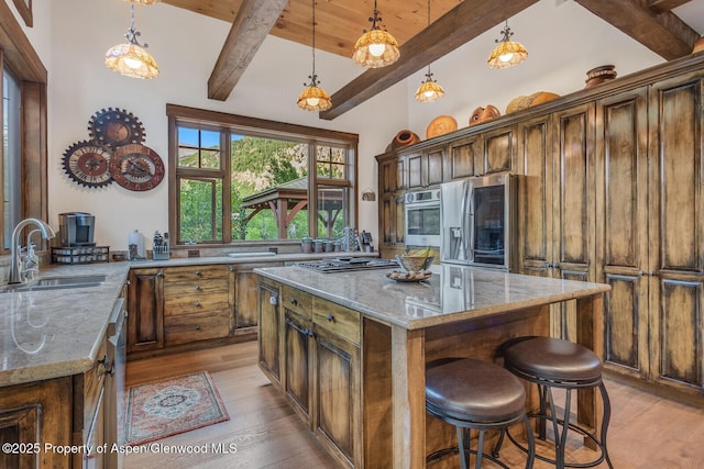 606 Dorais Way, Redstone, CO 81623 - kitchen featuring light wood-type flooring, light stone counters, stainless steel appliances, a breakfast bar area, and a wooden ceiling with exposed beams
