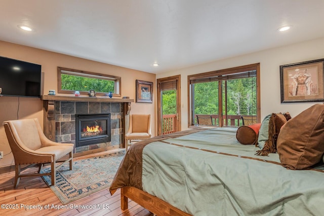 606 Dorais Way, Redstone, CO 81623 - bedroom with wood finished floors, a tiled fireplace, recessed lighting, and access to outside