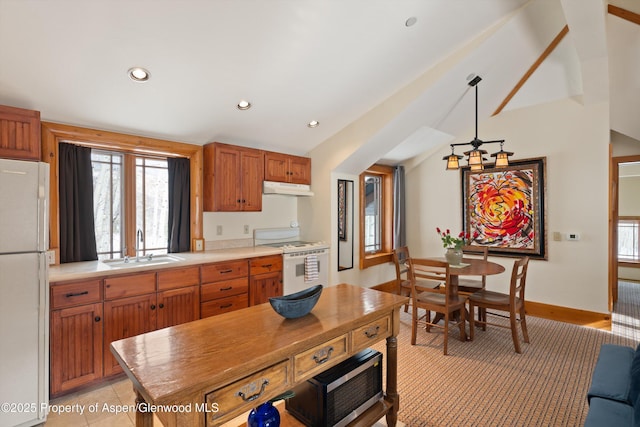 kitchen with a sink, white appliances, light countertops, lofted ceiling, and under cabinet range hood