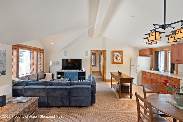 living room with baseboards, a wealth of natural light, vaulted ceiling with beams, and light colored carpet