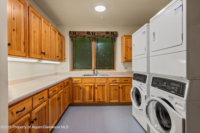 laundry room with washing machine and dryer, a sink, stacked washing maching and dryer, and cabinet space