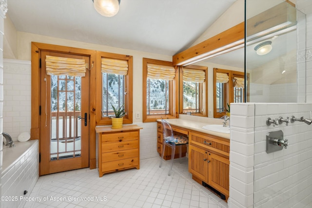 bathroom featuring plenty of natural light, vaulted ceiling, and vanity