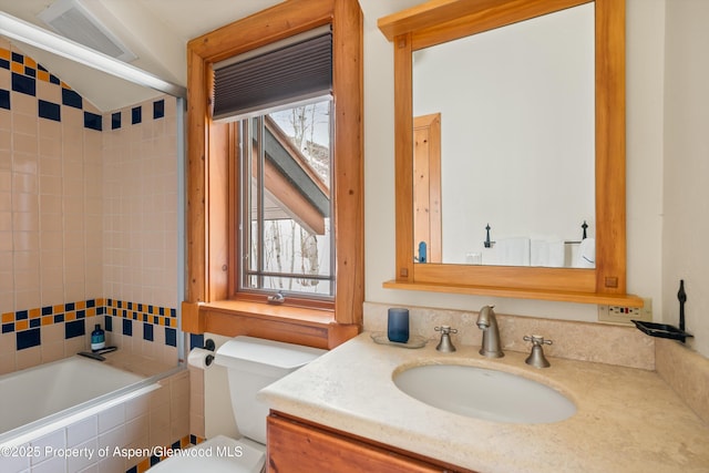 full bathroom with vanity, tiled shower / bath, and toilet