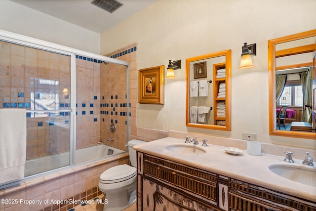 full bathroom with tiled shower / bath combo, visible vents, toilet, and a sink