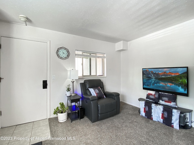 tiled living room featuring a textured ceiling