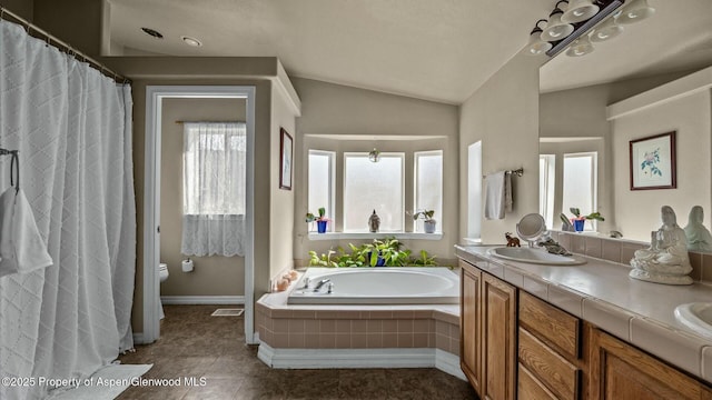 full bath with a garden tub, double vanity, toilet, vaulted ceiling, and a sink