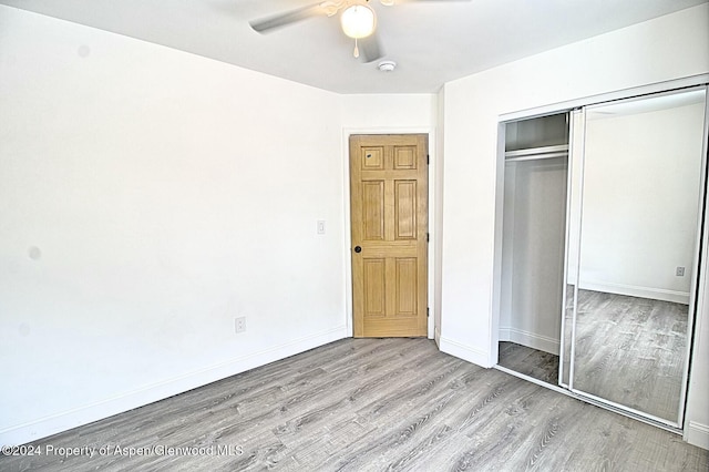 unfurnished bedroom with ceiling fan, light hardwood / wood-style floors, and a closet