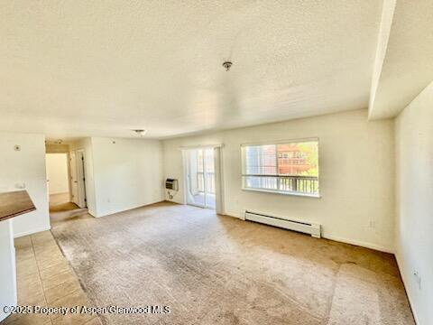 612 River View Dr Unit 804, New Castle, CO 81647 - unfurnished living room featuring baseboard heating, a textured ceiling, and light colored carpet
