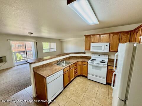 612 River View Dr Unit 804, New Castle, CO 81647 - kitchen featuring white appliances, a peninsula, light tile patterned floors, brown cabinetry, and a textured ceiling
