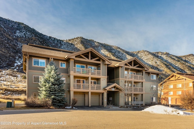 view of front of home featuring a garage, aphalt driveway, and a mountain view