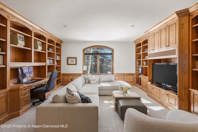 living room with light carpet, built in desk, built in features, and wooden walls