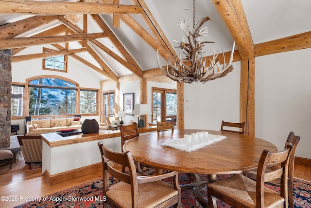 dining room featuring french doors, wood-type flooring, beam ceiling, and a notable chandelier