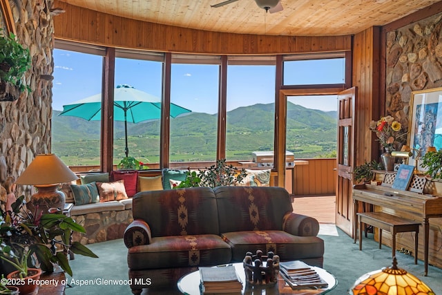 1789 Medicine Bow Rd, Aspen, CO 81611 - carpeted living area featuring wooden walls, a mountain view, wooden ceiling, and ceiling fan