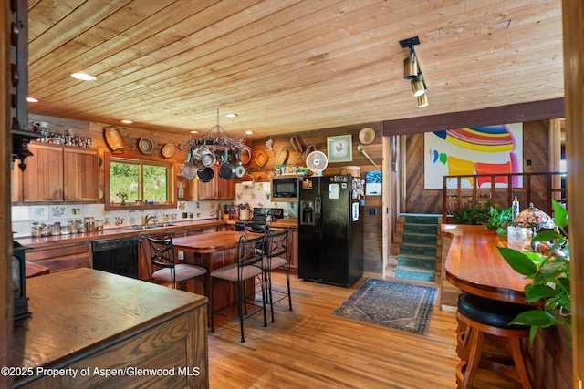 1789 Medicine Bow Rd, Aspen, CO 81611 - kitchen featuring black appliances, wood ceiling, light wood-style floors, wood walls, and wood counters