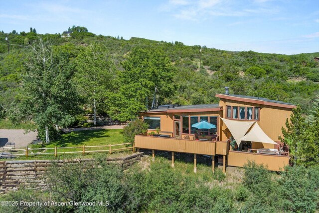 1789 Medicine Bow Rd, Aspen, CO 81611 - rear view of house featuring a forest view and a deck