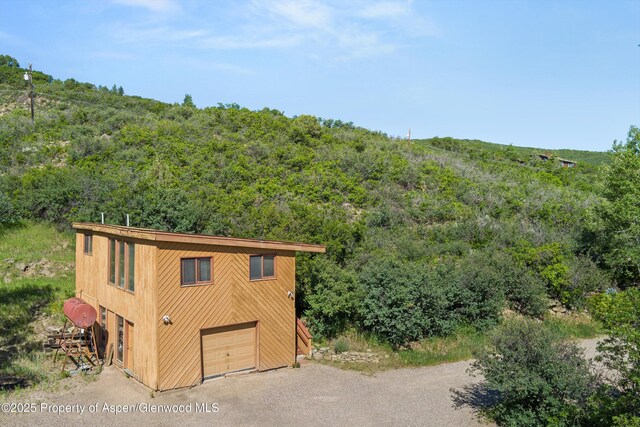 1789 Medicine Bow Rd, Aspen, CO 81611 - view of outdoor structure featuring a garage, a view of trees, and driveway
