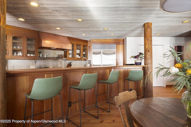 172 Deer Ridge Ln, Snowmass Village, CO 81615 - bar area featuring custom range hood, stainless steel built in refrigerator, hardwood / wood-style flooring, and recessed lighting
