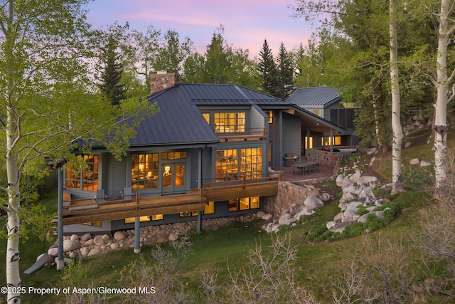 172 Deer Ridge Ln, Snowmass Village, CO 81615 - back of property at dusk featuring a chimney and metal roof