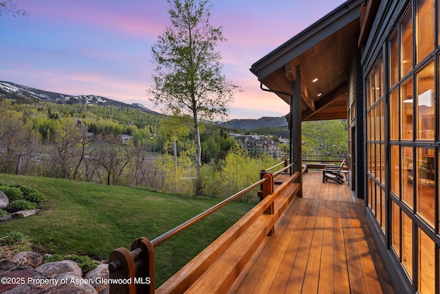 172 Deer Ridge Ln, Snowmass Village, CO 81615 - deck at dusk featuring a mountain view and a lawn