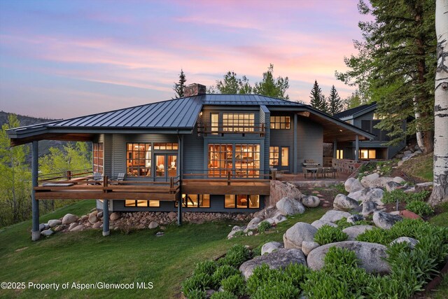 172 Deer Ridge Ln, Snowmass Village, CO 81615 - back of house with a standing seam roof, a chimney, metal roof, a yard, and a wooden deck