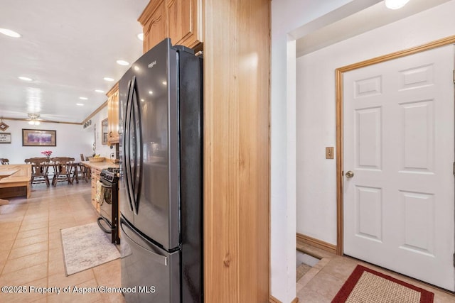kitchen featuring a ceiling fan, black gas stove, light tile patterned floors, freestanding refrigerator, and recessed lighting