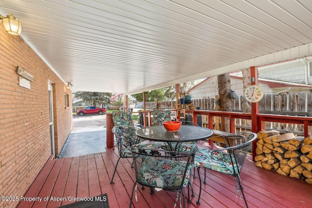 wooden terrace featuring outdoor dining area and fence