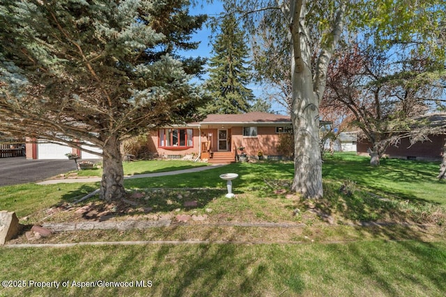 view of front facade with brick siding, aphalt driveway, a front yard, and a garage