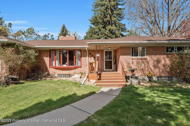 ranch-style home with brick siding, a chimney, roof with shingles, and a front lawn