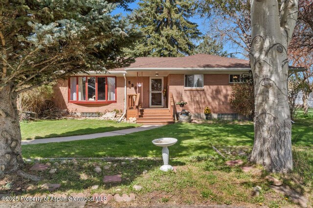 single story home with brick siding and a front lawn