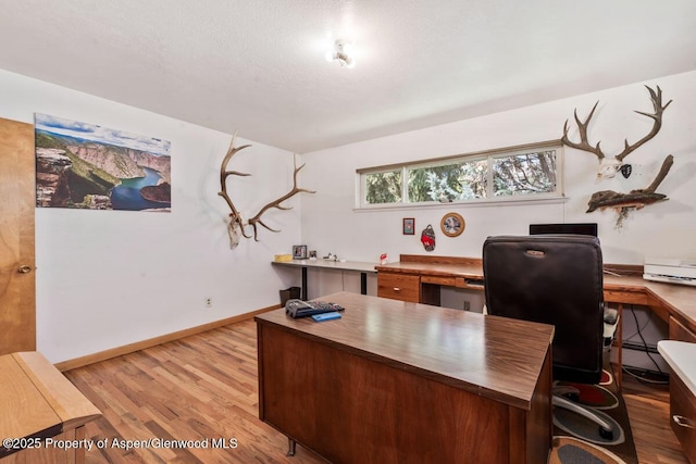 office featuring baseboards and light wood-type flooring