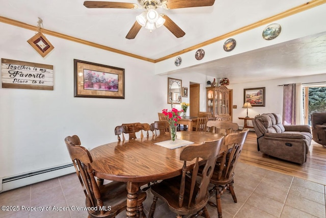 dining room featuring ceiling fan, ornamental molding, baseboard heating, and light tile patterned flooring