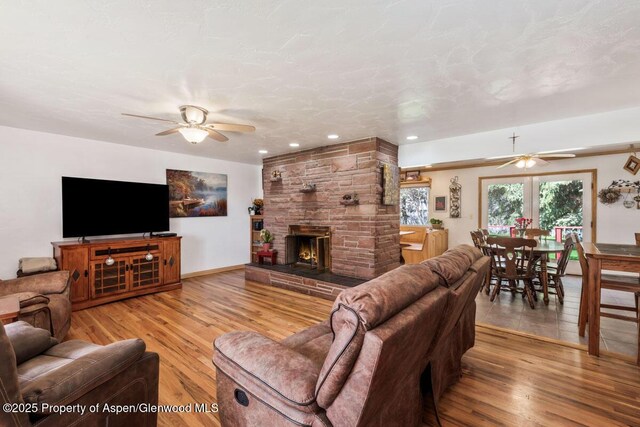 living area with ceiling fan, a fireplace, recessed lighting, and wood finished floors