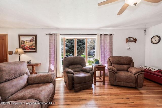 living area featuring a ceiling fan and wood finished floors