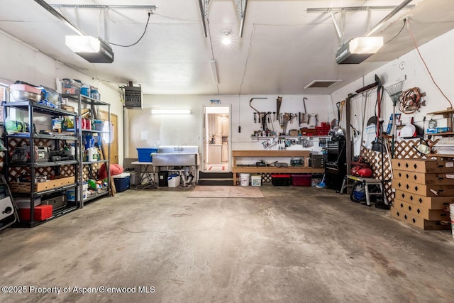 garage with a workshop area and a garage door opener
