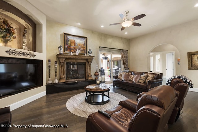 living room featuring ceiling fan and dark hardwood / wood-style floors