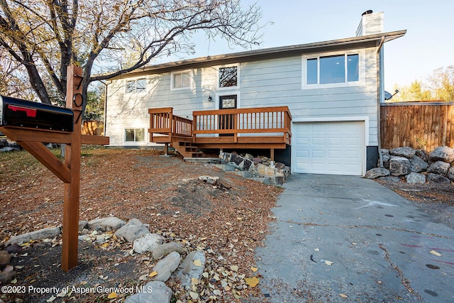 view of front facade featuring a wooden deck and a garage