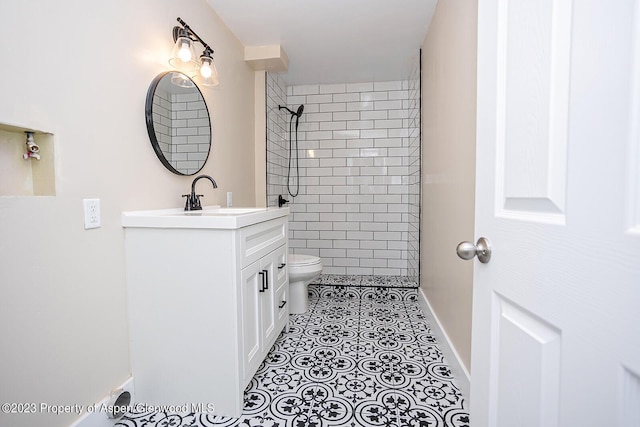 bathroom with vanity, toilet, tile patterned flooring, and a tile shower
