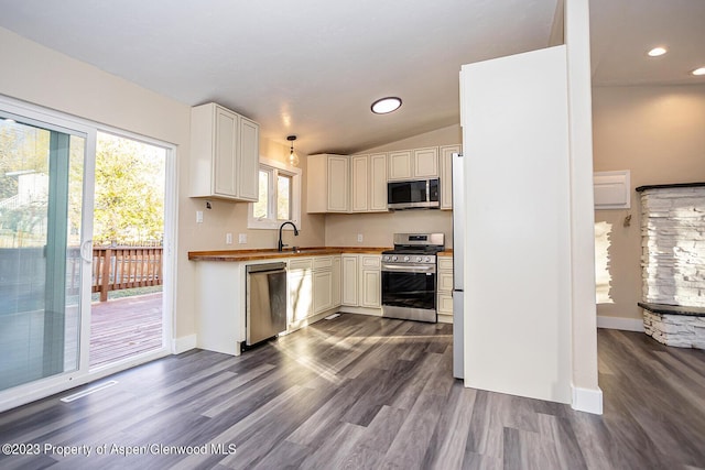kitchen featuring white cabinetry, hanging light fixtures, stainless steel appliances, and dark hardwood / wood-style floors