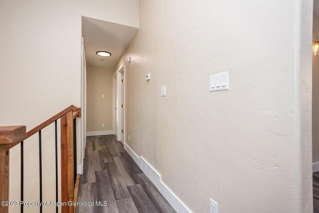 corridor with dark hardwood / wood-style flooring