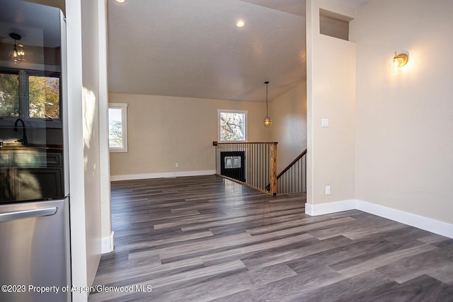 unfurnished living room featuring hardwood / wood-style flooring, plenty of natural light, and vaulted ceiling