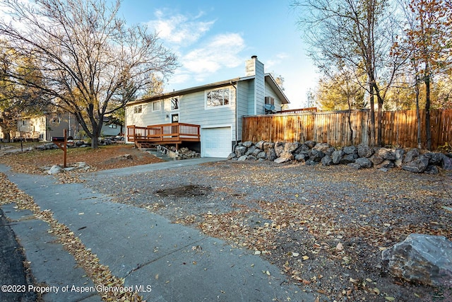 view of side of property with a wooden deck and a garage