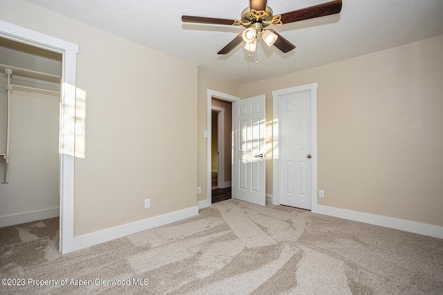 unfurnished bedroom featuring ceiling fan, light colored carpet, and a textured ceiling