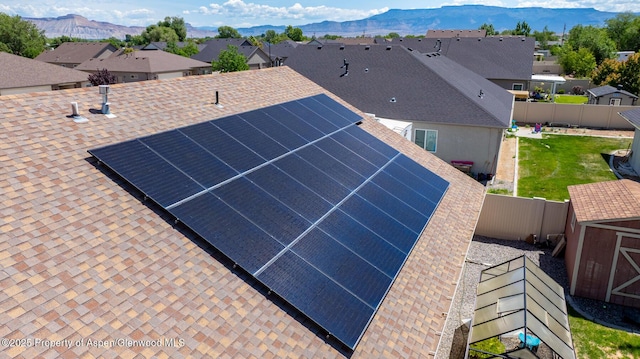 2939 Jon Hall Rd, Grand Junction, CO 81503 - exterior view of roof with shingles, a mountain backdrop, a residential view, and a fenced backyard