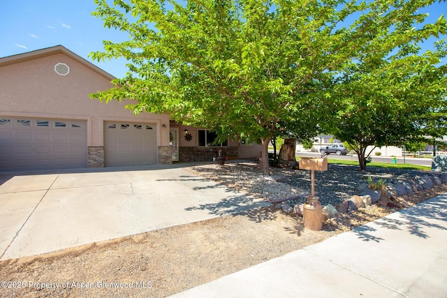 2939 Jon Hall Rd, Grand Junction, CO 81503 - view of front facade featuring a garage, driveway, stucco siding, and stone siding