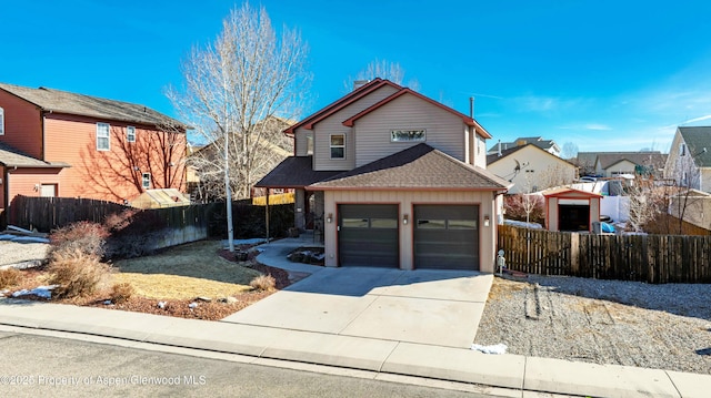 traditional home featuring driveway, fence private yard, a shingled roof, and a residential view